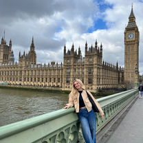 A girl standing on the bridge posing in front of Big Ben