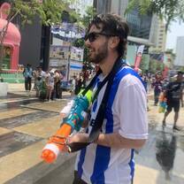 A photograph of a teacher with a watergun during songkran