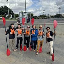 group of students holding kayaking ors