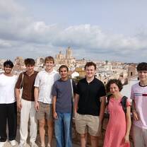 CET Barcelona students and staff standing by a view of Tarragona on a cloudy day