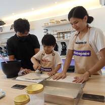 A student practicing English while participating in a cookie-making lesson.