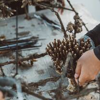 A close up shot of hands attaching a coral piece to the structures