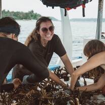 Smiling divers planting coral on structures on the dive boat