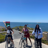 Three girls posing for a photo on bikes