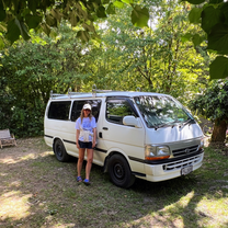 A woman standing in front of a campervan