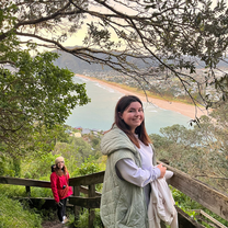 Two woman on a mountain hike with the sea in the background