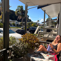 A woman sitting on an outdoor porch laughing
