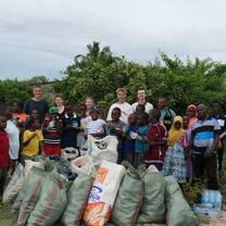 Volunteers and local children collecting waste during a beach clean-up