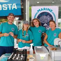 Marine conservation Interns preparing coral fragments indoors.