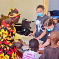 Volunteers and local staff documenting patient information inside the Maisha clinic during a medical care day
