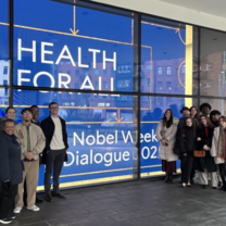 Group of students next to a sign of the Nobel Week event