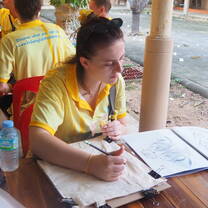 A teacher participating in a traditional Thai art workshop at UNESCO Park, Sukhothai KET Orientation. 