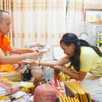 Teacher Kalia receiving a traditional blessing from a Thai monk.