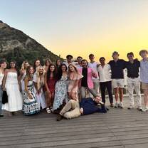 Group of students celebrating graduation by the European coast during a study abroad program