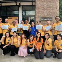 The Kids English Thailand team and 2026 summer teachers posing together outside the residency headquarters.