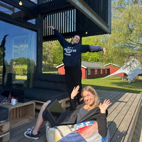 Two interns working outside on bean bags on a porch