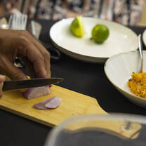 Guest slicing an onion in a local home