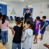 English teacher engaging students in movement-based learning activity.
