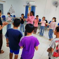 Teacher leading energetic classroom activity with students standing and participating.