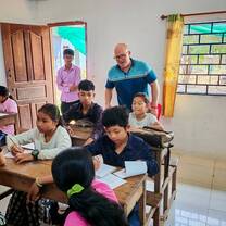 Teacher observing students during live English teaching practicum in classroom.