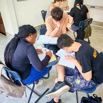 TEFL trainees working together on lesson plans in small group setting.