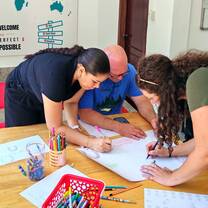 Trainees designing classroom materials and posters using colored markers.