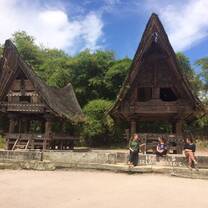 AFS Students sitting in front of old traditional houses in Indonesia