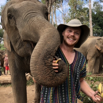 Smiling teacher of English with an elephant in Thailand