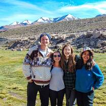 Group of students pose in front mountains.