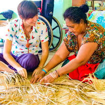 Student learns basket weaving from a local woman.