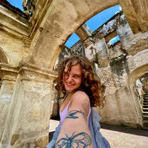 Smiling female TEFL teacher visiting the El Carmen Ruins in Antigua, Guatemala.