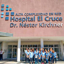 Students pose in front of a hospital.