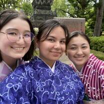 Three students smiling in a selfie, wearing their kimonos
