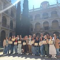 Students with certificates at historic university campus 