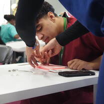 Student practising suturing techniques during a hands-on emergency medicine summer school in Liverpool