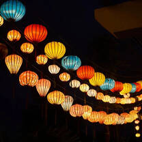 multi-colored lanterns hanging against the night sky