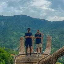 two boys standing on a large wooden structure