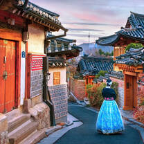 woman walking through historic buildings in traditional clothing