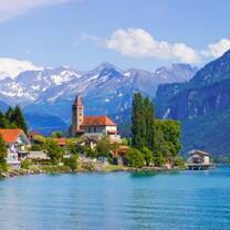 a beautiful building on a lake in the Swiss mountains