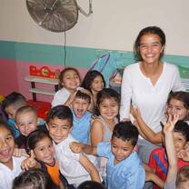 Volunteer supporting children with classroom activities during a childcare volunteer program in Heredia, Costa Rica.