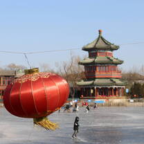 A lantern in the foreground of an ice skating scene