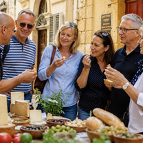 Mature students attending a food tour in Valetta, Malta. Trying food from the market.