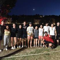 A group of students smiling while standing on a field at night