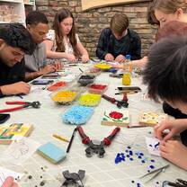 Students working on putting together small mosaic tiles