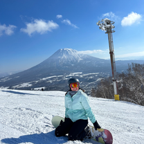 Woman on a snowy mountain with a snowboard. Mt Fuji in the back