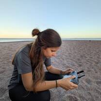 Volunteer recording sea turtle data on the beach at sunset during a night patrol in Costa Rica