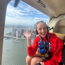 Woman in a helicopter with the NYC skyline in the background