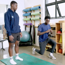 Physical therapy intern at his internship site, assisting an injured athlete with recovery