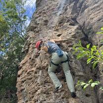 A girl rock climbing on the side of a mountain