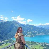 A lady looking over her shoulders at the camera behind her is a scenery of mountains